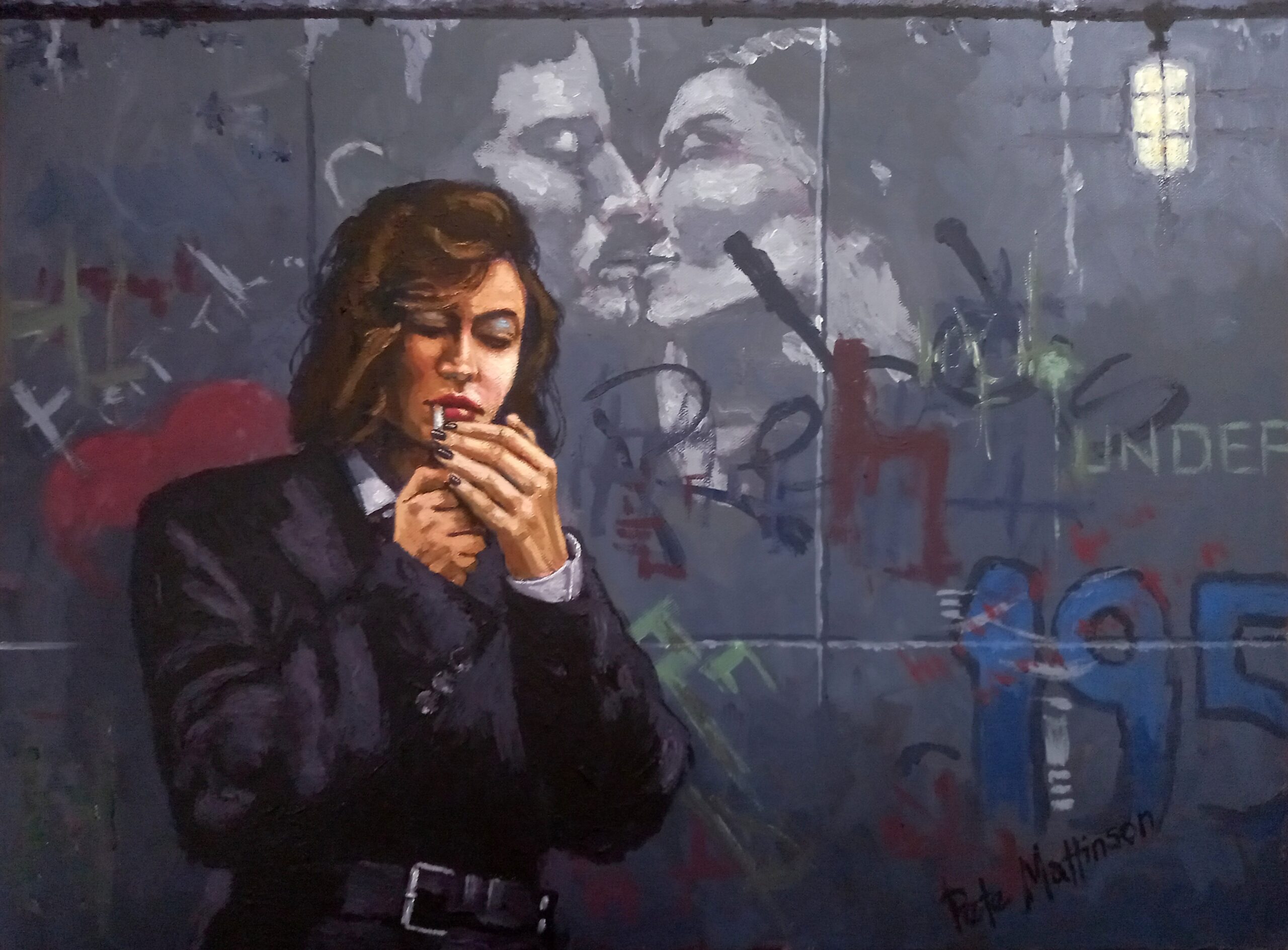 Girl lighting a cigarette in front of a street hoarding covered in graffiti