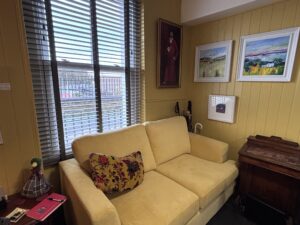 Yellow sofa in front of a sash window in the lounge of Y Segontiwm arts and music bar