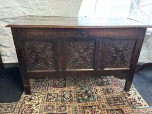 Oak coffer with intricate carving on the front panels