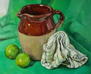 Image of an earthenware jug on a green table cloth with two limes and a tea towel