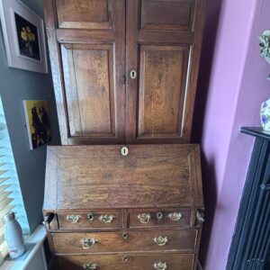 vintage desk with drawers and a bookcase with doors above.