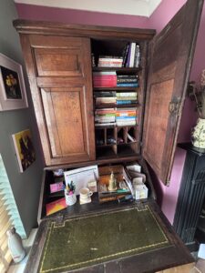 a bookcase on top of a bureau with drawers and various compartments